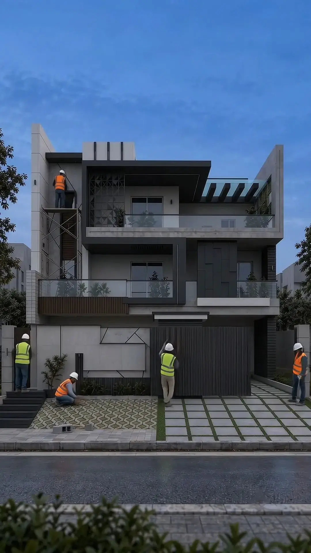 Narrow three-storey house under construction with workers on scaffolding at dusk